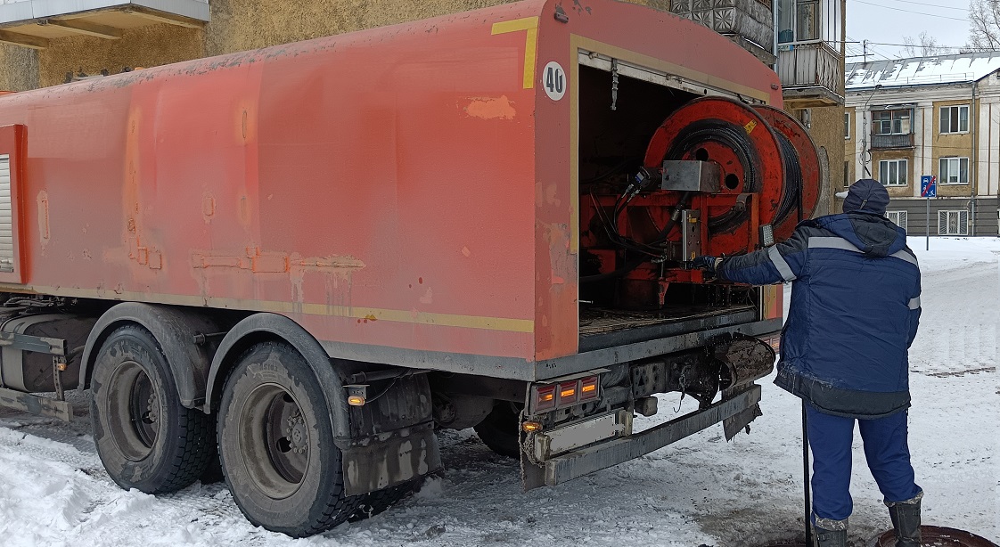 Каналопромывочная машина и работник прочищают засор в канализационной системе в Егорьевске